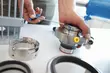 Techniker montiert präzise Metallbauteile und Dichtungen einer Industrieanlage auf einer Werkbank während einer technischen Wartung.